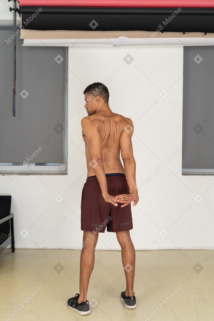 Back view of man doing reverse shoulder stretch