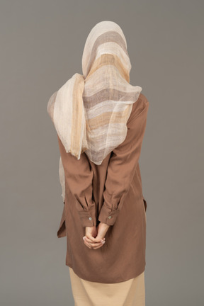Back view of a woman folding hands behind the back