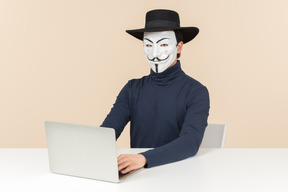 Hacker sentado frente a la computadora portátil