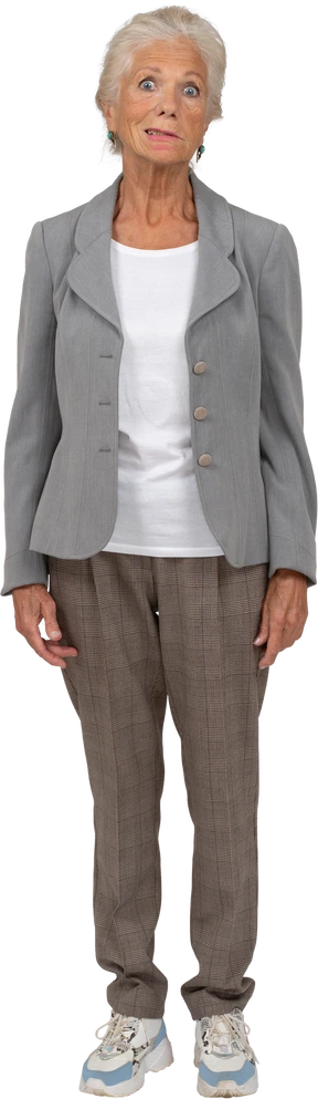 Vista frontal de una anciana en traje mirando a la cámara