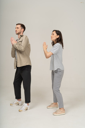 Vista lateral do homem e da mulher com as mãos em oração