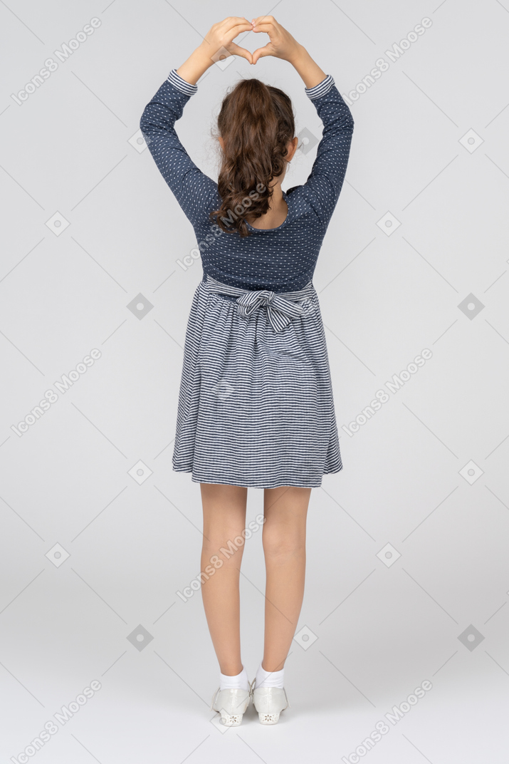 一个穿着灰色t恤，双臂交叉站在墙前的女人