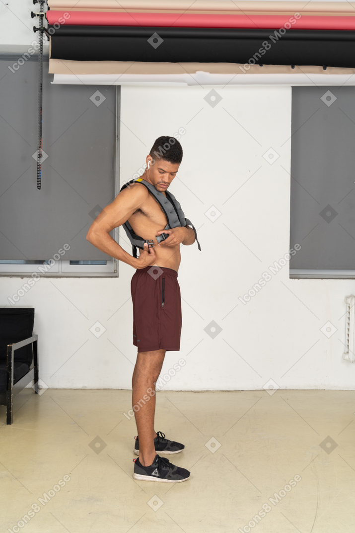 Side view of man adjusting weighted vest