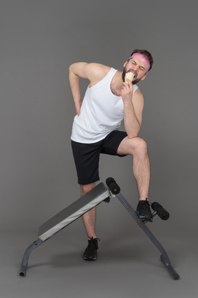 A young man having an ice cream during a workout