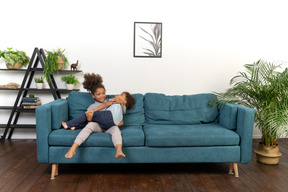 Good looking boy and girl play on the sofa