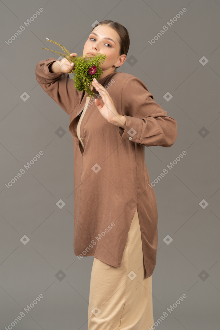 Young woman holds a bouquet near her face