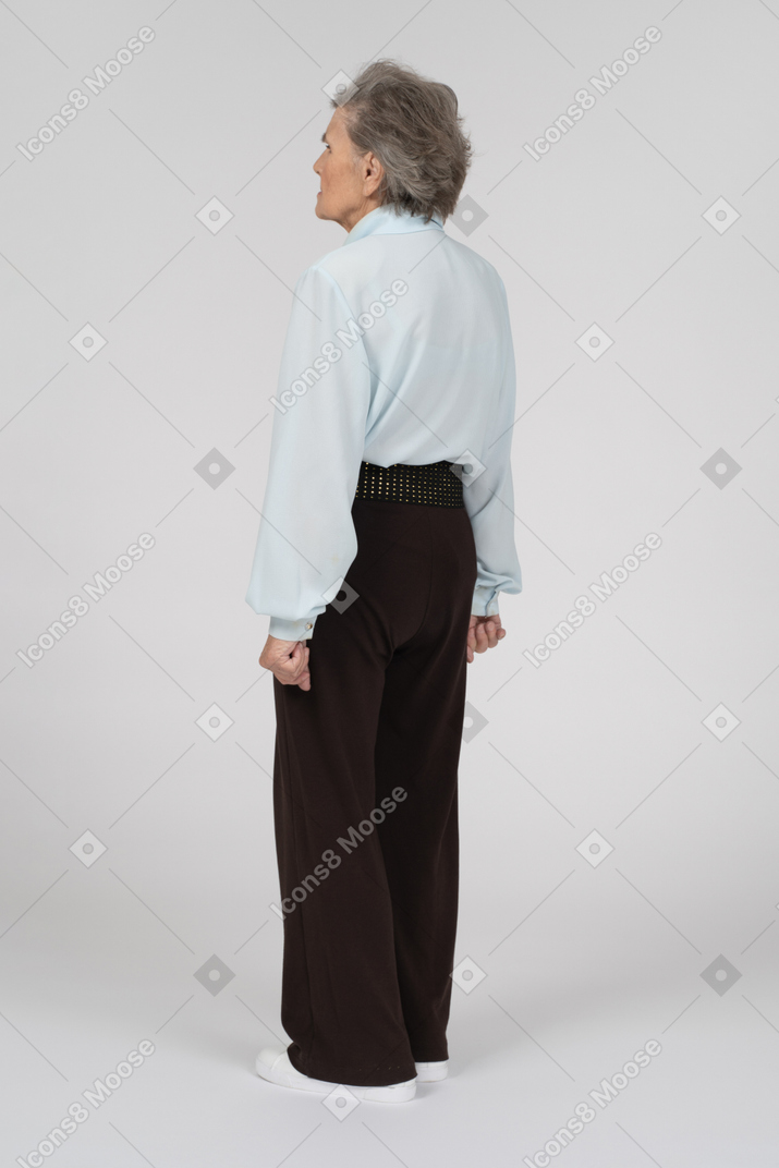 Vista posteriore di tre quarti di una donna anziana in piedi