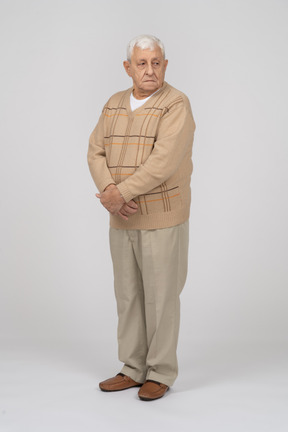 Front view of an old man in casual clothes looking aside