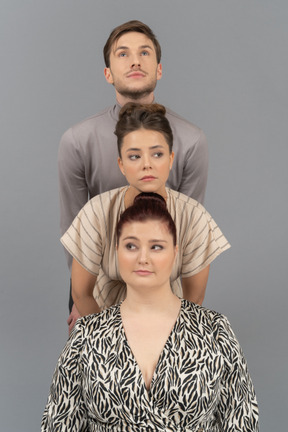 Two young women and a man standing in a row