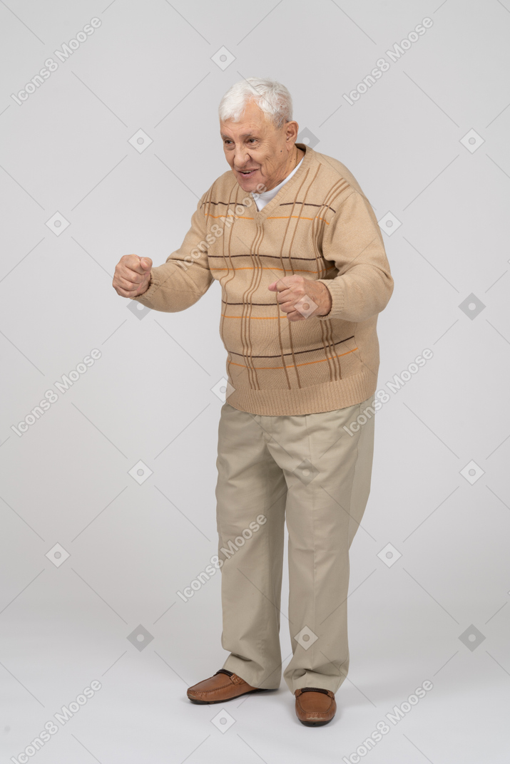 Front view of a happy old man in casual clothes explaining something