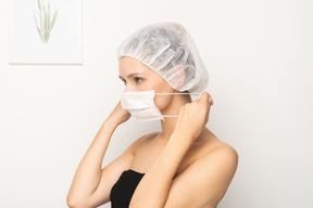 Woman putting on mask