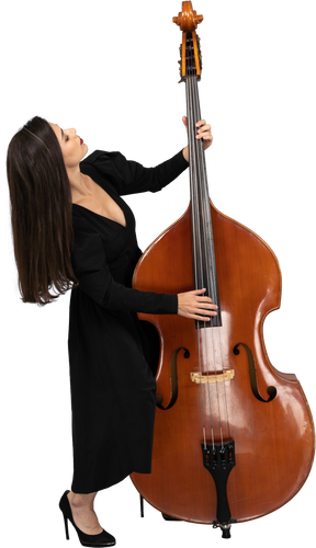 Figura intera di una giovane donna in abito nero che suona il contrabbasso mentre si appoggia allo schienale