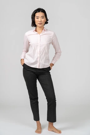 Woman in office clothes standing with hands on hips