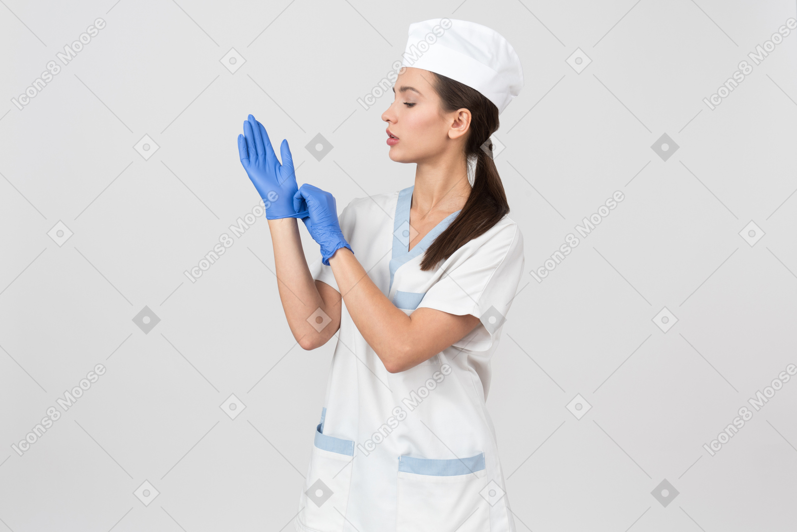 Enfermeira atraente em um manto médico colocando luvas de látex