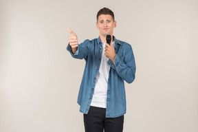Laughing young stand-up presenter showing thumb up