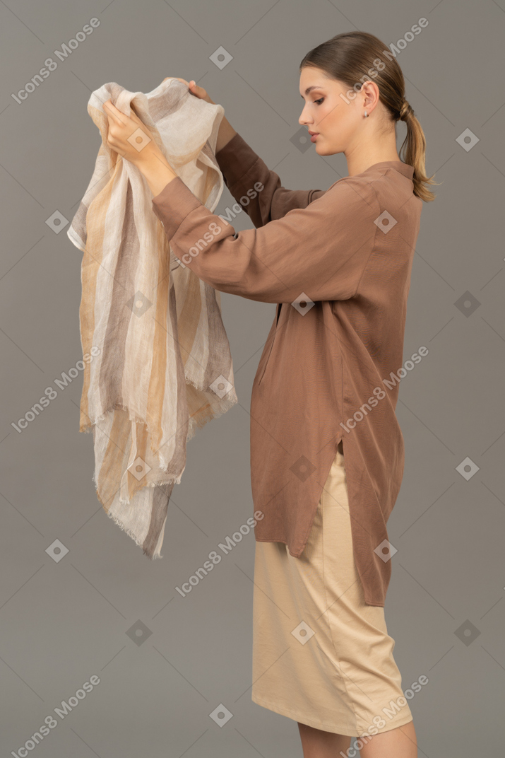 Vista lateral, de, un, mujer joven, tenencia, un, bufanda