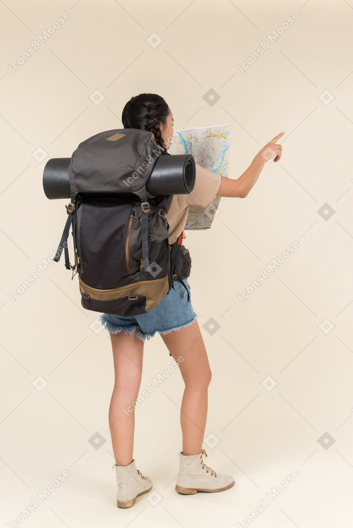 Young asian hiker showing directions from the map