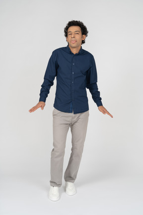 Vista frontal de um homem com roupas casuais mostrando a língua