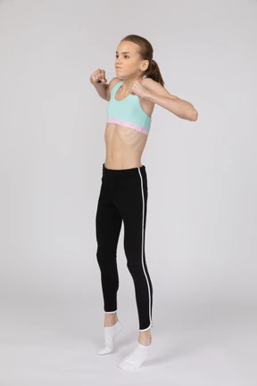 Side view of a teen girl in sportswear raising hand and arguing