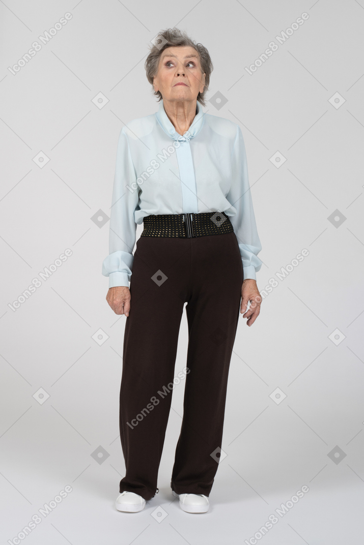 Vista frontal de una anciana mirando con cautela a la izquierda
