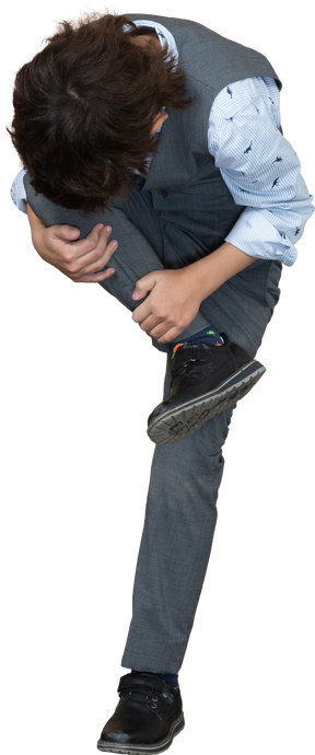 Vista frontal de um menino de terno cinza, esticando a perna