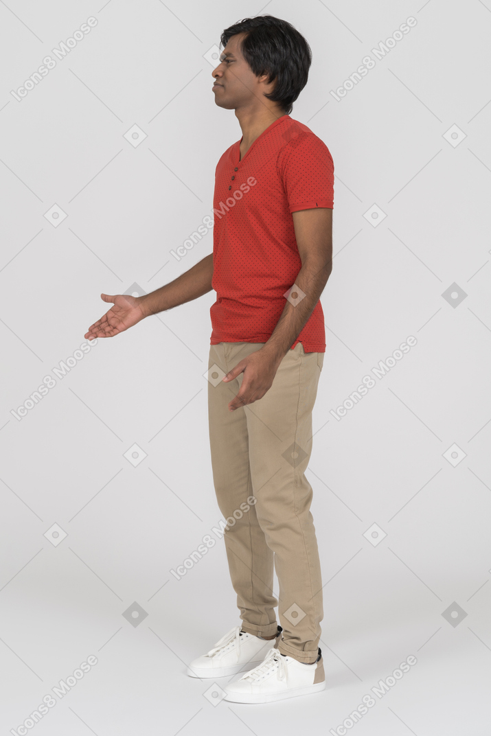 Side view of confused young man gesturing