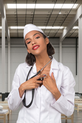 A woman in a white lab coat holding a stethoscope