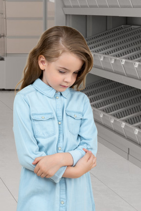 A little girl standing in front of a shelf