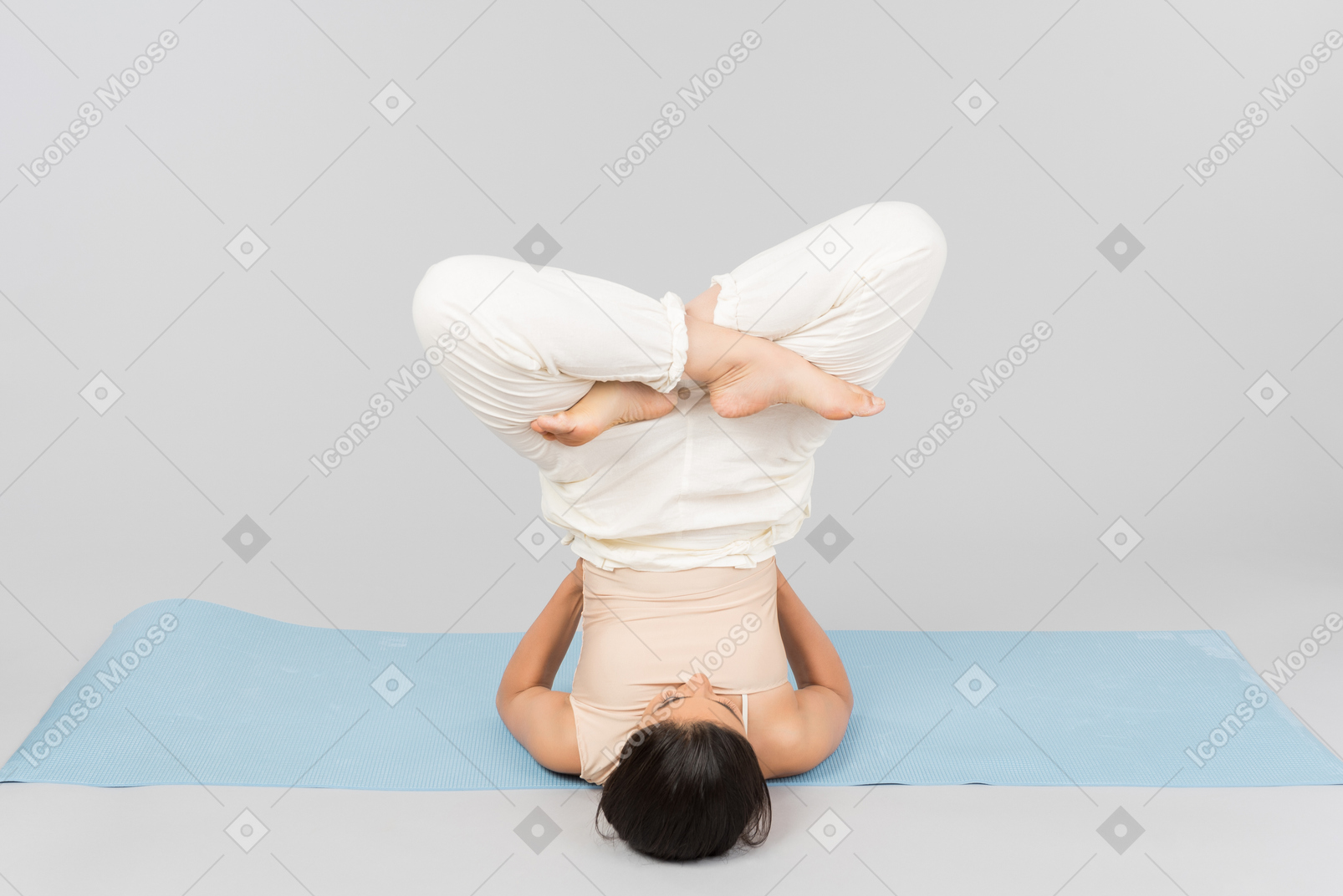 Junge indische frau, die auf kopf auf yogamatte liegt