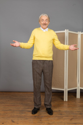 Front view of a smiling old man near the screen raising hands