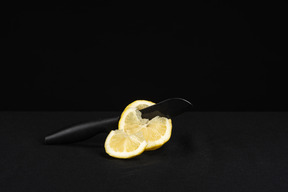 Knife cutting lemon in black background