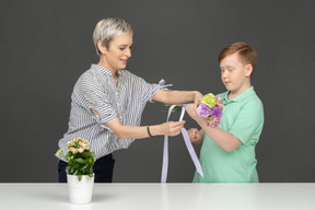 Mutter und sohn machen blumenstrauß