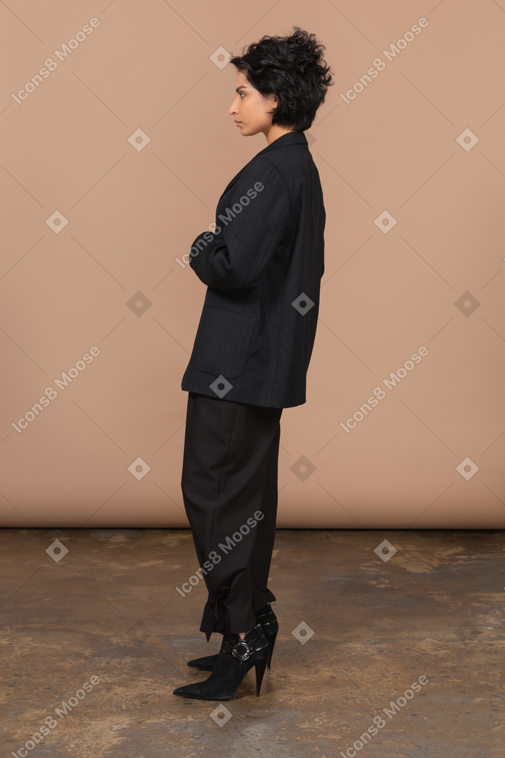 Side view of a serious businesswoman in a black suit looking angrily aside