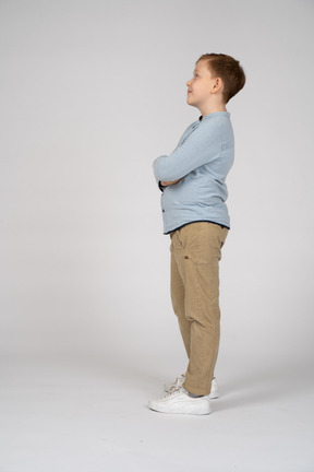 Niño posando con los brazos cruzados y mirando hacia arriba