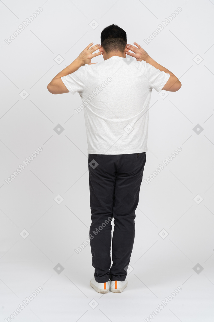 Man in casual clothes standing back to camera and listening attentively