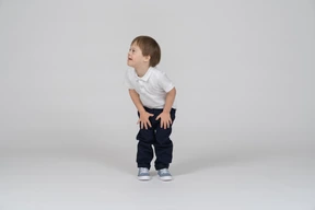 Little boy standing with his hands on his thighs