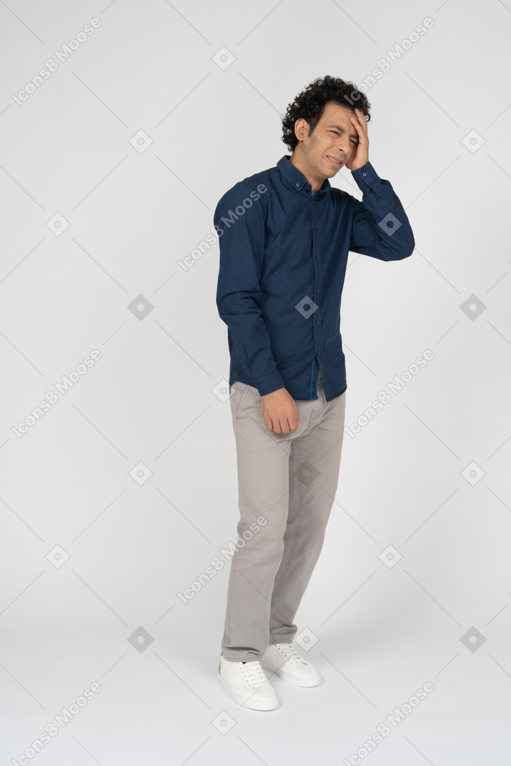 Вид спереди мужчины в повседневной одежде, страдающего головной болью