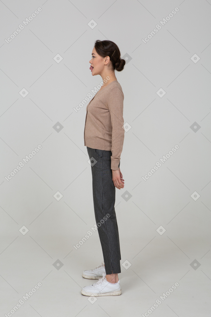 Vue latérale, de, a, jeune femme, dans, pullover, et, pantalon, projection, langue