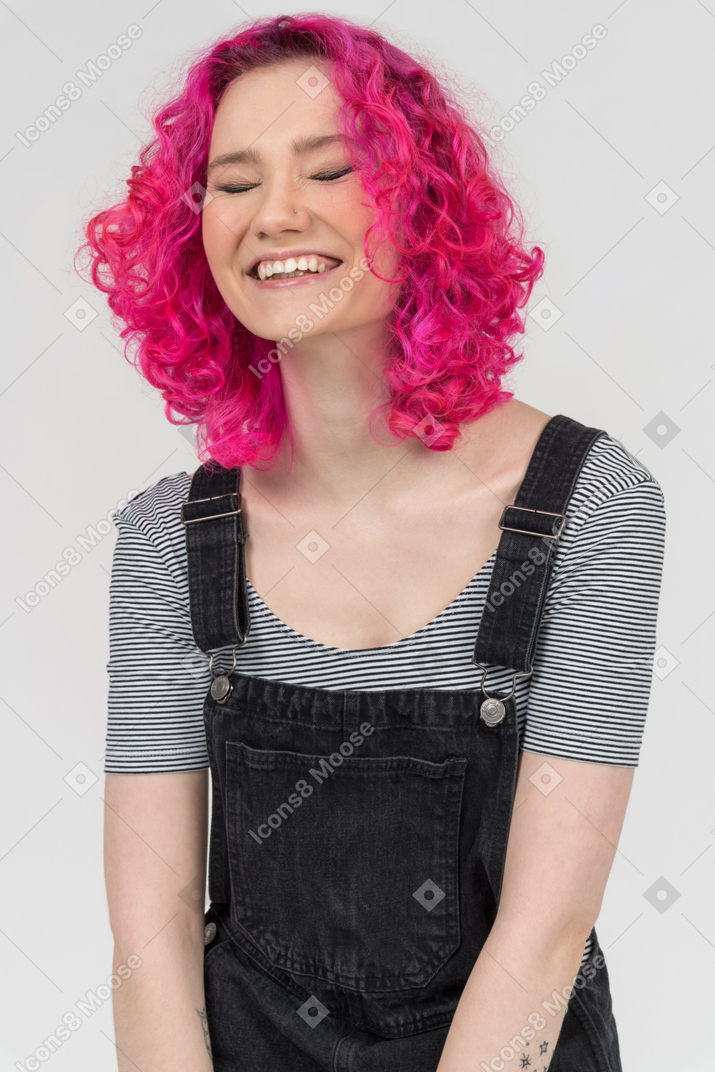 Uma menina de cabelos rosa alegre rindo alto