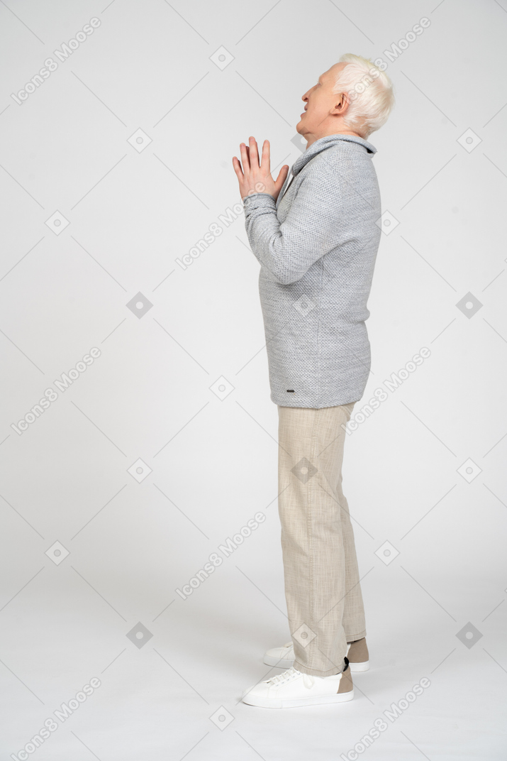 Side view of man standing upright with hand in prayer