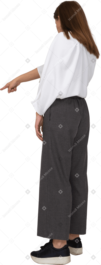Vue de trois quarts arrière d'une jeune femme en vêtements de bureau pointant le doigt
