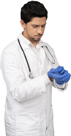 Arzt zieht blaue handschuhe an