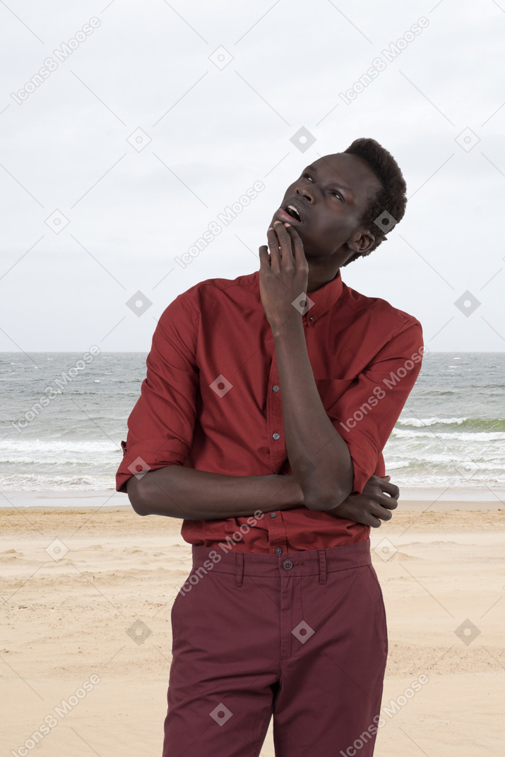 Hombre parado en la playa y pensando