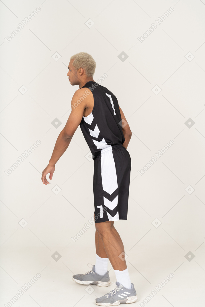 Side view of a walking young male basketball player