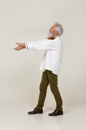Joyeux homme d'âge moyen marchant avec les bras tendus