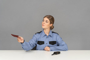 A female security guard holding a passport