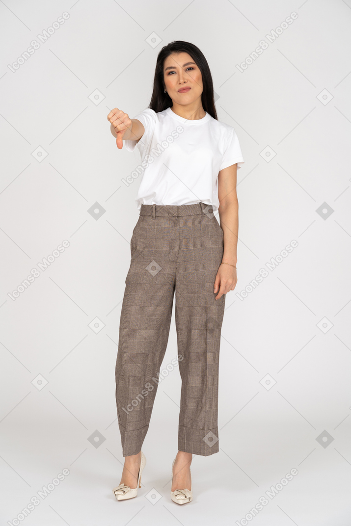 Vista frontal de una señorita en calzones y camiseta mostrando el pulgar hacia abajo