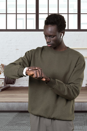 Standing man looking at his wristwatch