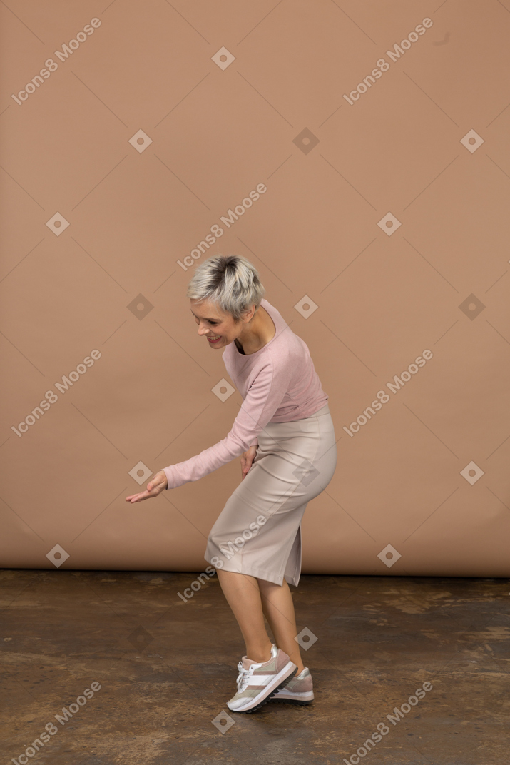 Vue latérale d'une femme en vêtements décontractés faisant un geste de bienvenue
