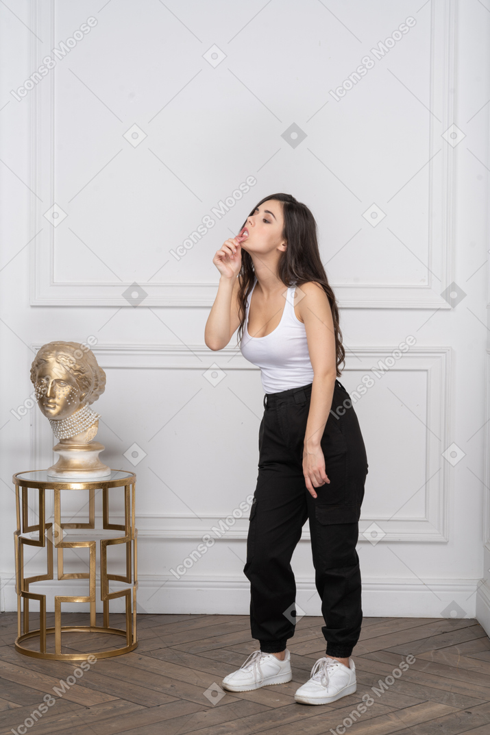 Mujer joven en camiseta sin mangas tocando su labio